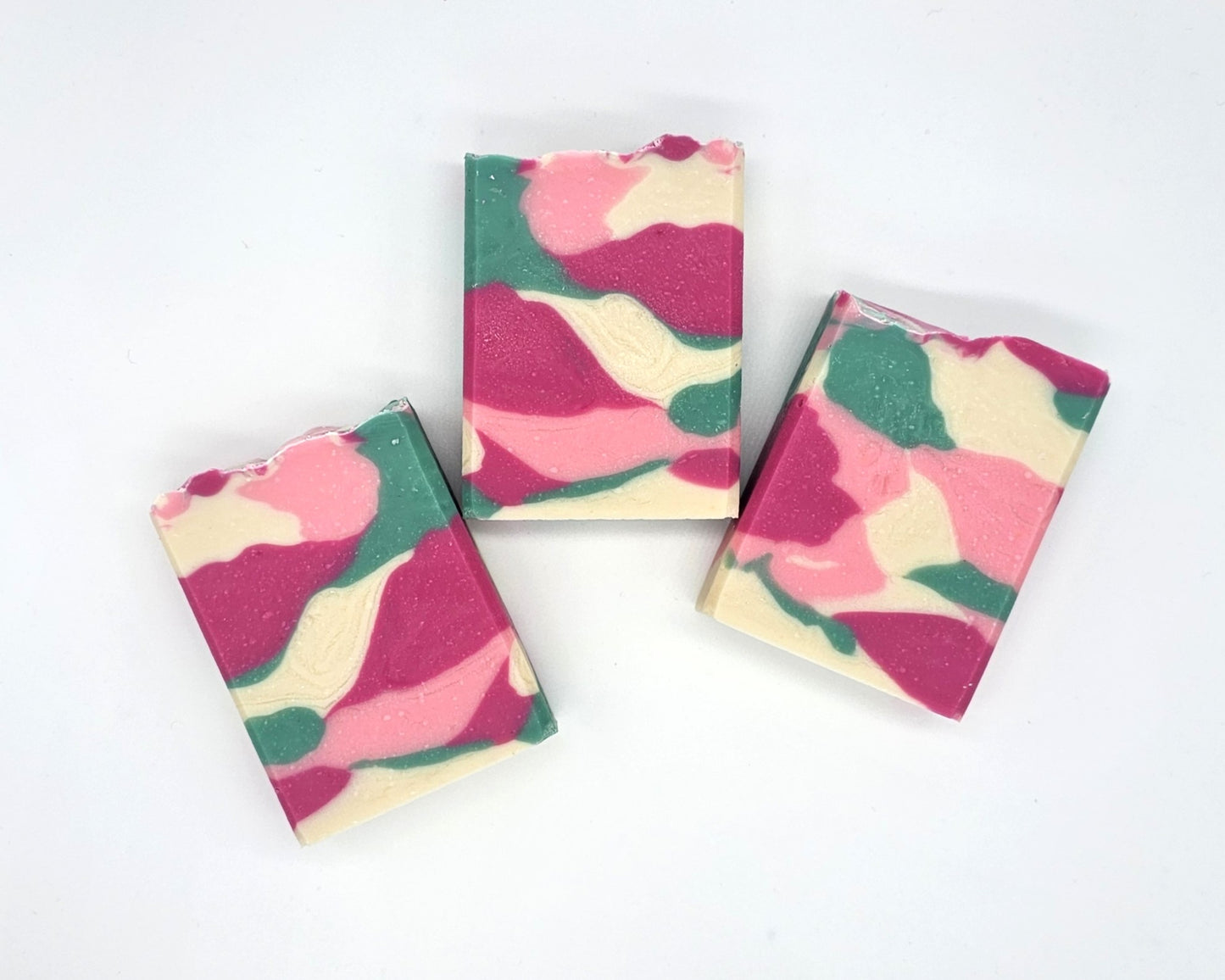 Three rectangular Willow Blossom Goat Milk Soap bars from Amillia Acres, featuring a pink, green, cream, and white marbled pattern, are arranged on a plain white background.
