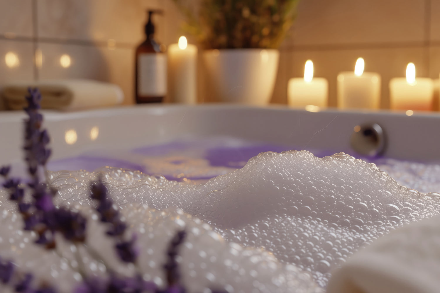 A cozy bathroom scene with a bubble-filled bathtub, surrounded by lit candles and a plant. Lavender flowers are in the foreground, adding a calming touch to the warm, relaxing atmosphere.