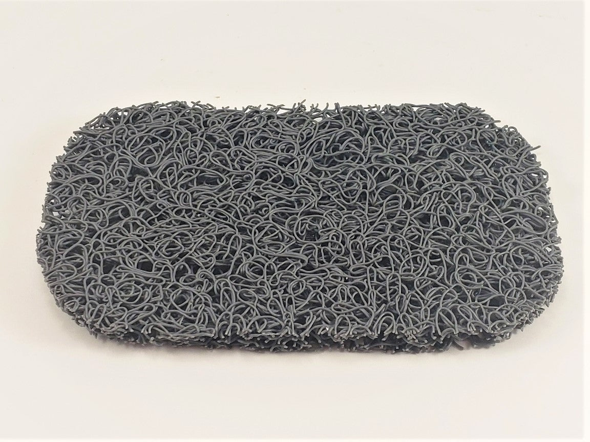 The Amillia Acres Soap Saver is a rectangular gray pad with a textured, curly surface that looks like tightly wound loops of wire, set against a plain white background to help maximize the lifespan of your soap.