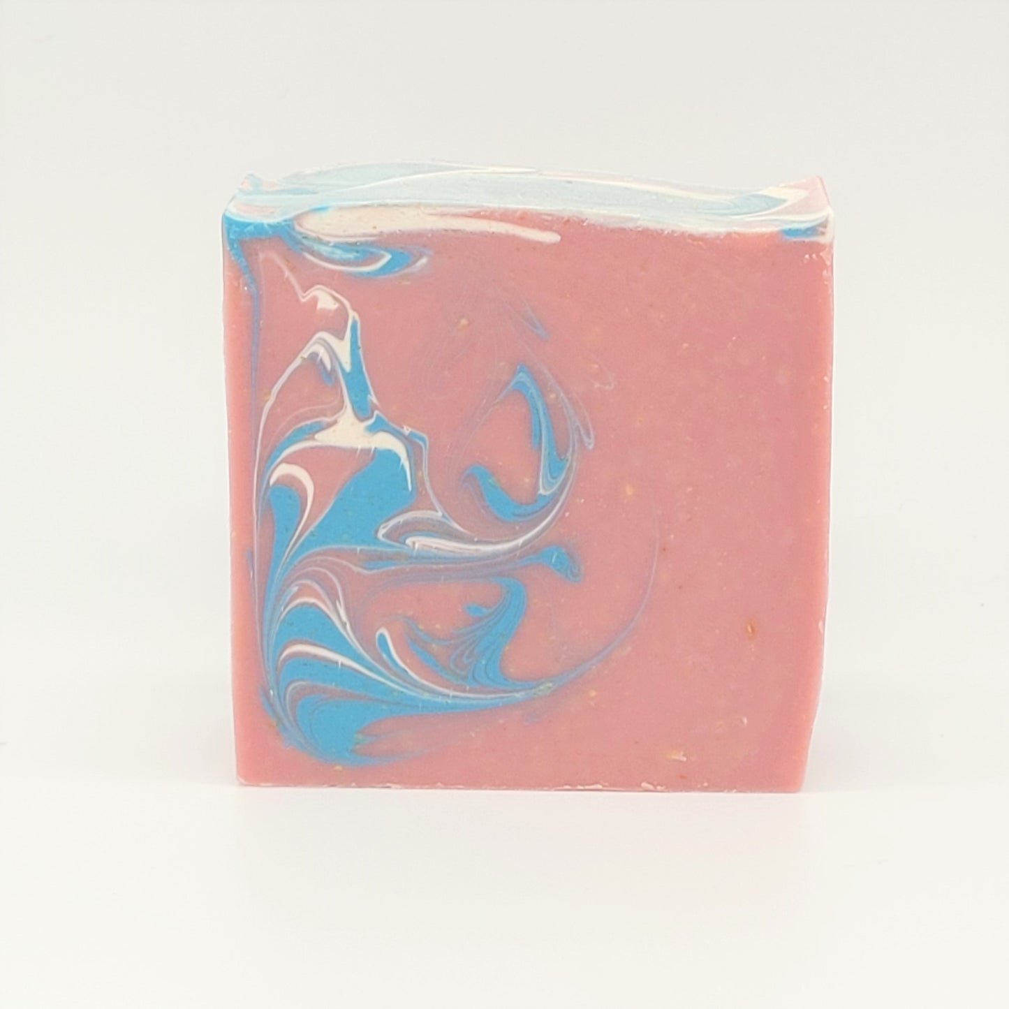 A rectangular bar of "Escape" goat milk soap by Amillia Acres features a decorative swirl pattern in white and blue on the surface, set against a white background highlighting its vibrant colors.