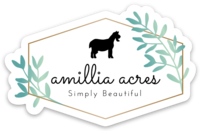 The Amillia Acres ~ Goat Milk Soaps and Lotions logo, showcasing a horse silhouette with the tagline "Simply Beautiful," is set in a hexagonal frame with green and blue leaves. Crafted on durable vinyl, this design makes perfect die cut stickers.
