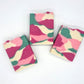 Three rectangular Willow Blossom Goat Milk Soap bars from Amillia Acres, featuring a pink, green, cream, and white marbled pattern, are arranged on a plain white background.