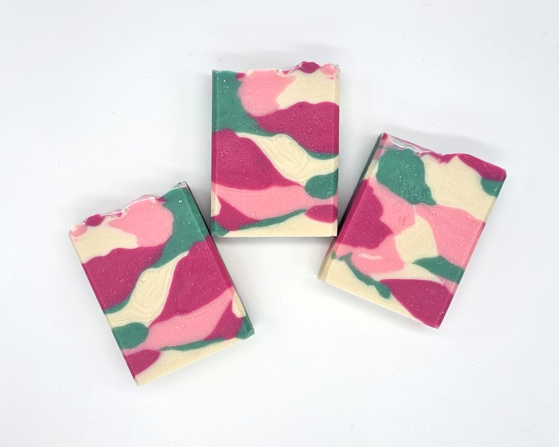 Three rectangular Willow Blossom Goat Milk Soap bars from Amillia Acres, featuring a pink, green, cream, and white marbled pattern, are arranged on a plain white background.
