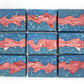 Nine Liberty Goat Milk Soap bars by Amillia Acres ~ Goat Milk Soaps and Lotions, each blue with white speckles and a wavy marbled red-and-white stripe, are arranged in a neat 3x3 grid on a white background.