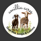 Illustration of two goats on grass with flowers, featuring "Amillia Acres" in script above and "Goat Milk Soaps & Lotions" in bold below. The design, set on a white circle against a dark grey backdrop, is printed on durable vinyl for die cut stickers. Brand: Amillia Acres ~ Goat Milk Soaps and Lotions.