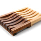 The Amillia Acres Wooden Soap Lift features interlocking curved slats in alternating light and dark wood, arranged in a rectangular pattern—ideal as a natural wood soap saver.