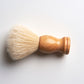 The Amillia Acres Classic Shave Brush features a light wooden handle and soft, cream-colored bristles, ideal for enhancing your grooming or shaving routine.