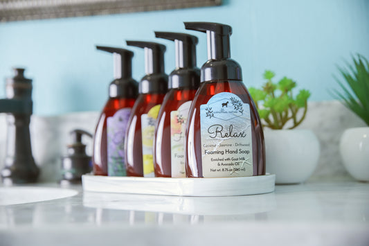 Four Amillia Acres ~ Goat Milk Soaps and Lotions foaming hand soap bottles with pumps sit on a white tray by a succulent, ready to pair with your REFILL - Foaming Hand Soap for your favorite custom scent.