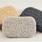 Three rectangular soap savers from Amillia Acres are presented: one in light beige, another in gray, and the last in dark gray. Each piece boasts a textured, woven surface designed to prolong the life of your soap. They are elegantly arranged on a white background.