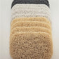 A set of six loofahs, marketed as Soap Savers by Amillia Acres, is displayed vertically with three beige layers at the base and three darker ones above. Their textured, curly design creates a layered look against a light backdrop, aiding in prolonging your soap's longevity.