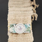 A set of four Exfoliating Soap Saver Bags made from natural sisal, each equipped with a drawstring. These pouches provide gentle exfoliation, and the packaging displays a label with the Amillia Acres brand on a dark background.